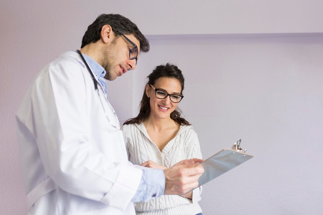 doctor-showing-clipboard-smiling-patient-standing-clinic_1048944-4383307